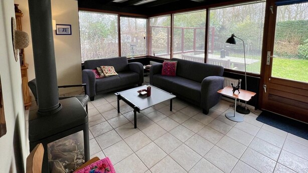 A cozy living room with two sofas, a coffee table, and a fireplace. - Bungalow for 4 People in Wildrijk (Sint Maartensvlotbrug)