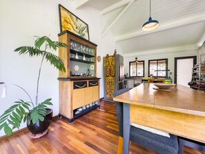 A spacious kitchen with wooden flooring, a central island, and a dining area. - Charme na Granja - Condomínio (Carapicuiba)