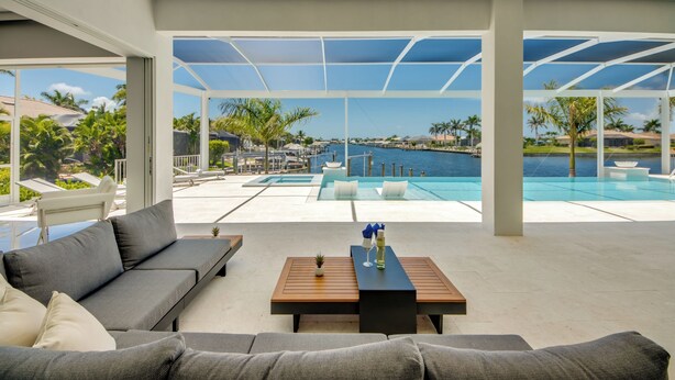 Un espacio exterior moderno con piscina, asientos y vistas al océano.