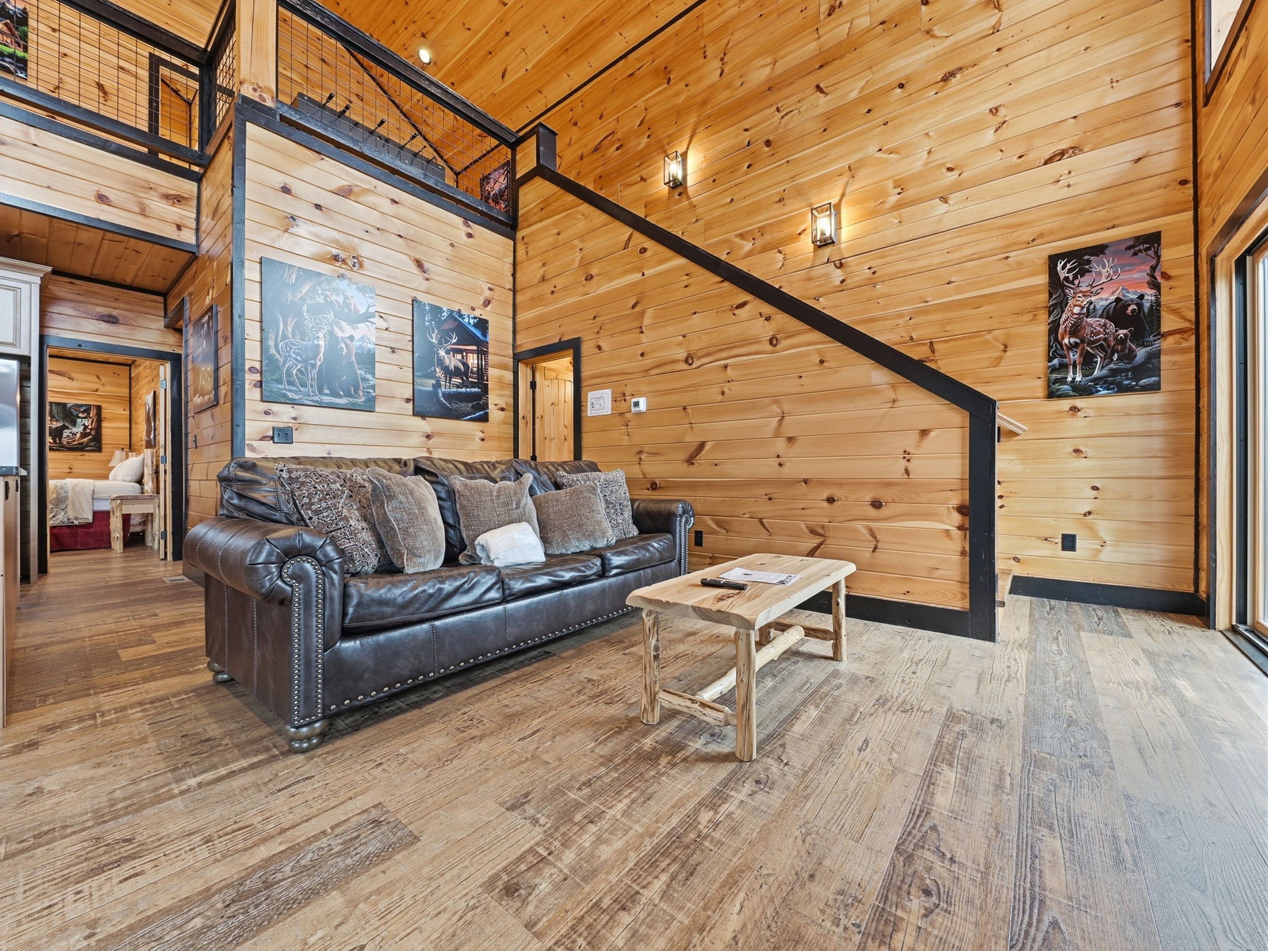 A cozy cabin interior with a wooden interior, a leather sofa, and a wooden coffee table.
