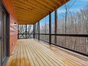 A wooden deck with a view of a forest.
