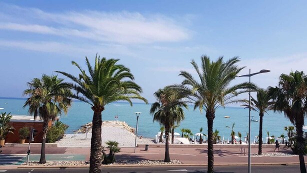 A coastal street with palm trees, a beach, and a clear sky. - Alpes maritimes front de mer cagnes sur mer  (Cagnes-sur-Mer)