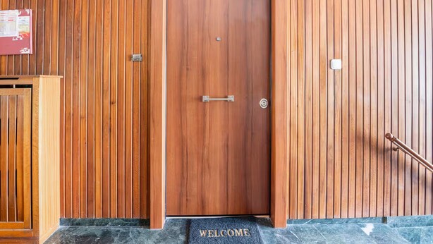 A wooden door with a 'WELCOME' mat at the entrance. - Athenian Entertainment Relaxation Hub (Athens)