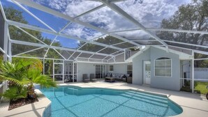A covered outdoor swimming pool with a glass ceiling, surrounded by a patio area with seating and a small building. - Waterview 3 Bed In Sunridge Woods 3 Bedroom Villa (Davenport)