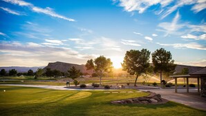 A golf course with a well-maintained lawn, a pavilion, and a mountain in the background. - Villa #30 At Bloomington Country Club - Red Cliffs 4 Bedroom Townhouse (St. George)