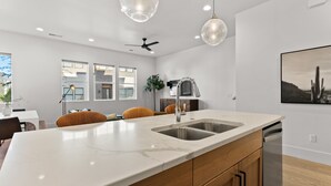 A modern kitchen with a large island, stainless steel appliances, and pendant lighting. - Villa #11 Adventure Retreat At Bloomington Villas 4 Bedroom Townhouse (St. George)