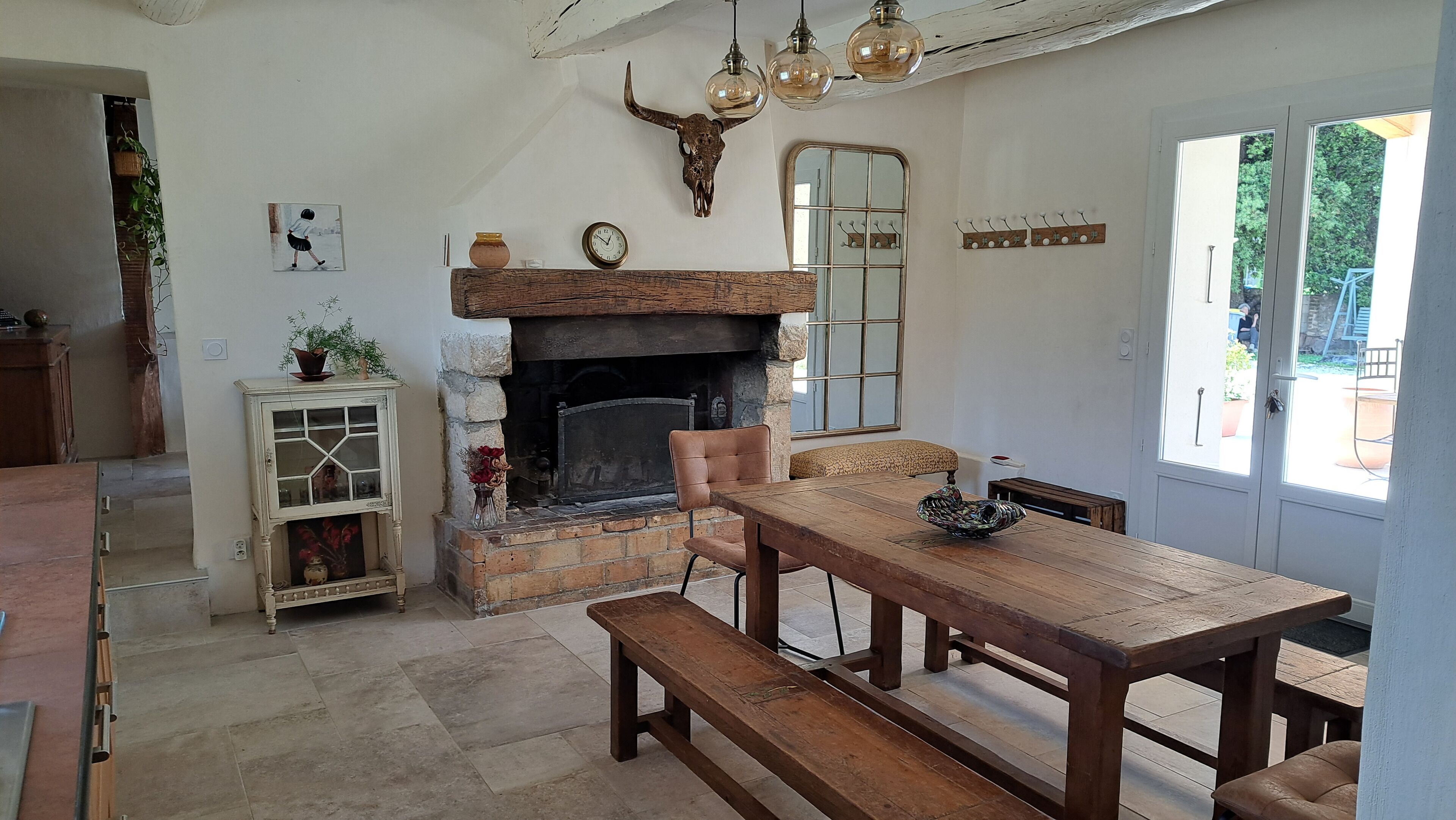 Un intérieur rustique agrémenté d’une cheminée, de meubles en bois et d’une décoration représentant un crâne de taureau.