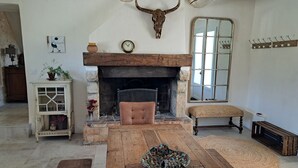 Ein gemütliches Wohnzimmer mit Kamin aus Stein, einer hölzernen Bank und rustikalem Einrichtungsstil.
