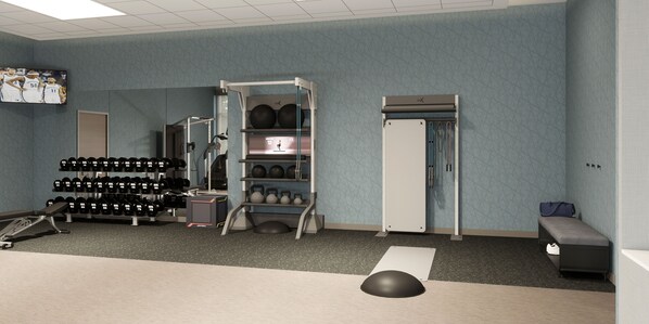 A gym with exercise equipment, a bench, and a wall-mounted TV. - Homewood Suites by Hilton Jackson (Jackson)