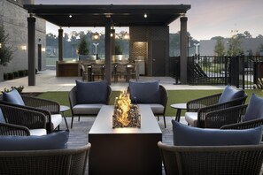 A patio area with outdoor seating, a fire feature, and a kitchen area. - Homewood Suites by Hilton Jackson (Jackson)