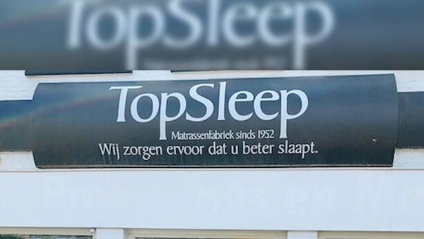 The exterior of a TopSleep store with a sign indicating it has been in business since 1952. There are two potted plants in front of the entrance. - Topsleep Apartments 26-1 (Arnhem)