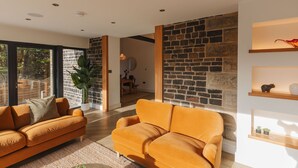 Una sala de estar moderna con una pared de piedra, un sofá y una mesa de centro.