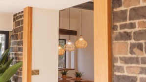 Una habitación con pared de piedra, marco de puerta de madera y una lámpara colgante.