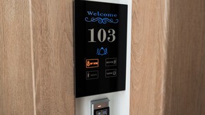 A digital hotel room number display with "Welcome 103" and various room service options. - Athens luxury suite 26 m2  (Athina)