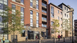 A multi-story building with a mix of brick and glass facades, a reception area, and a pedestrian walkway with trees. - For Students Only Central Pl Sheffield (Sheffield)
