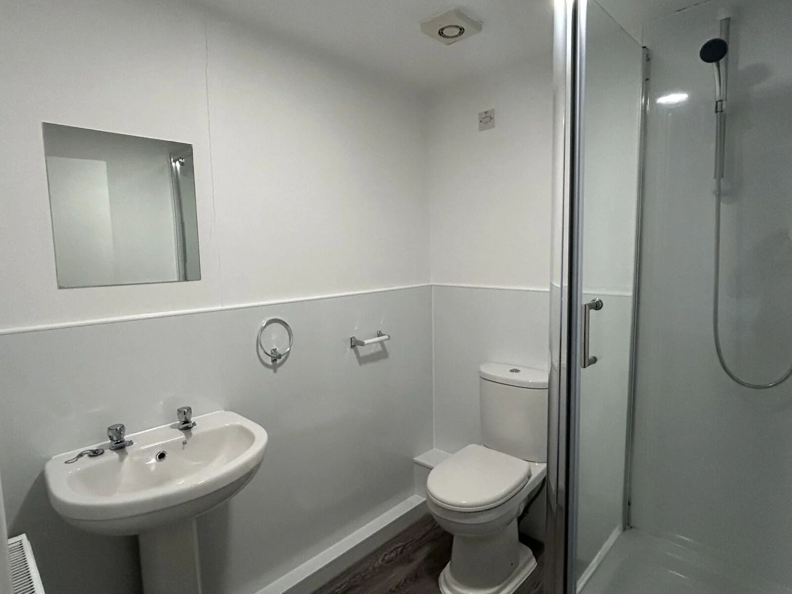 A bathroom with a sink, toilet, and glass-enclosed shower.