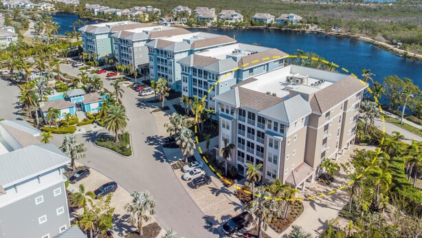 A coastal hotel with multiple buildings, a marina, and a view of the ocean.