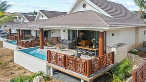 A modern villa with a pool, outdoor seating, and a covered patio.