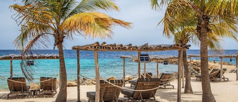 Una playa cerca, sillas reclinables de playa, toallas de playa