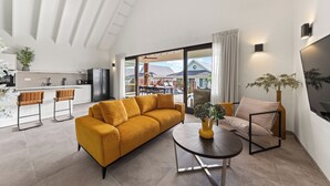 A modern living room with a sofa, a coffee table, and a dining area.