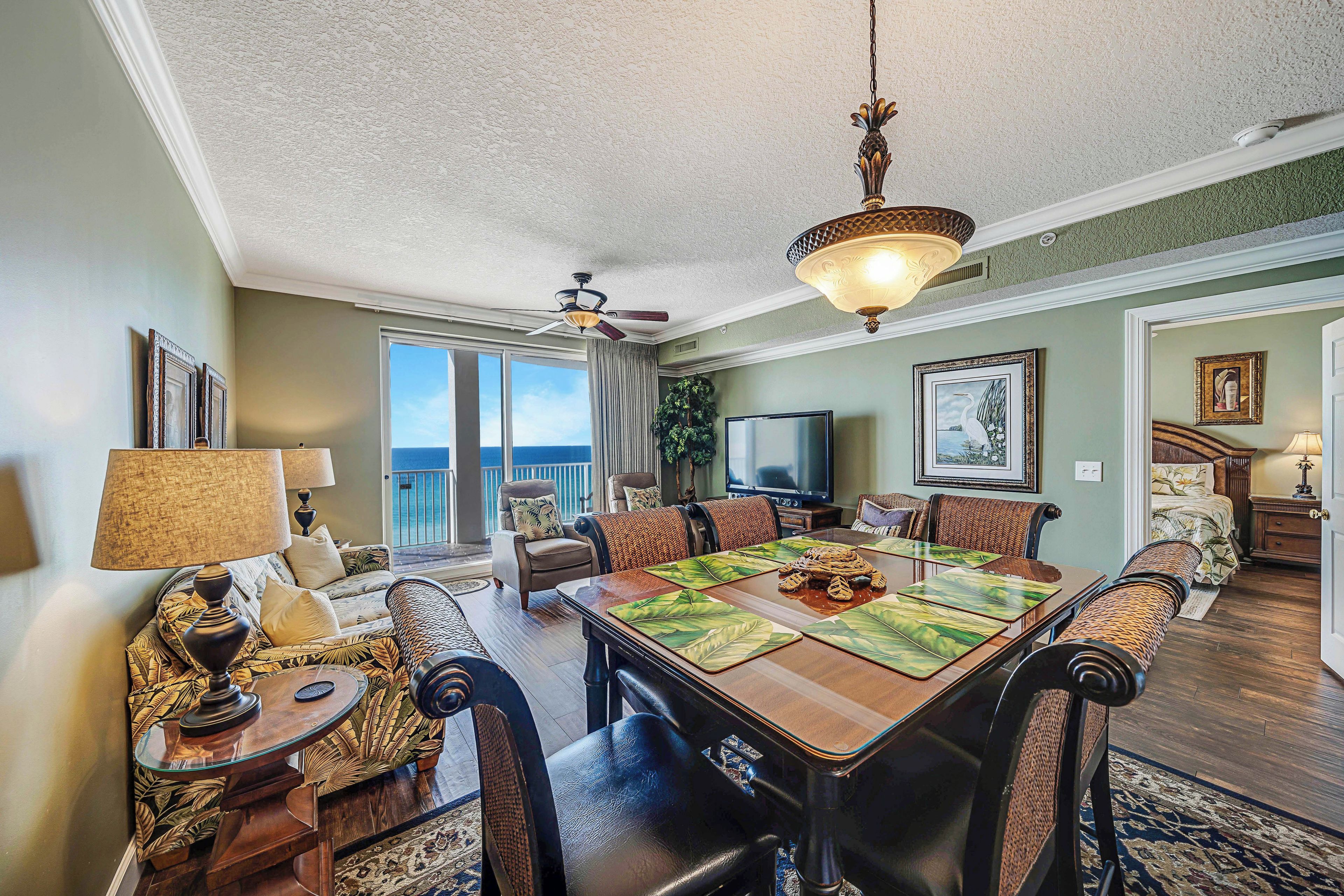 A dining area with a wooden table, chairs, and a ceiling fan.
