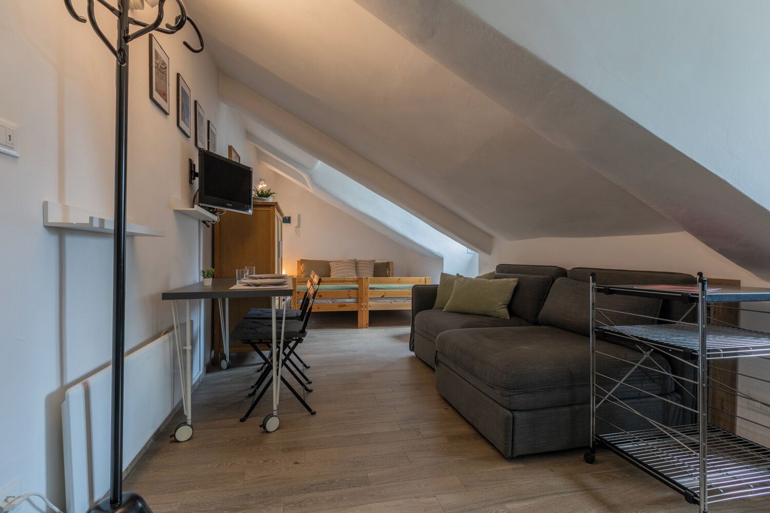 Un appartamento in stile loft con zona pranzo, divano e televisore.