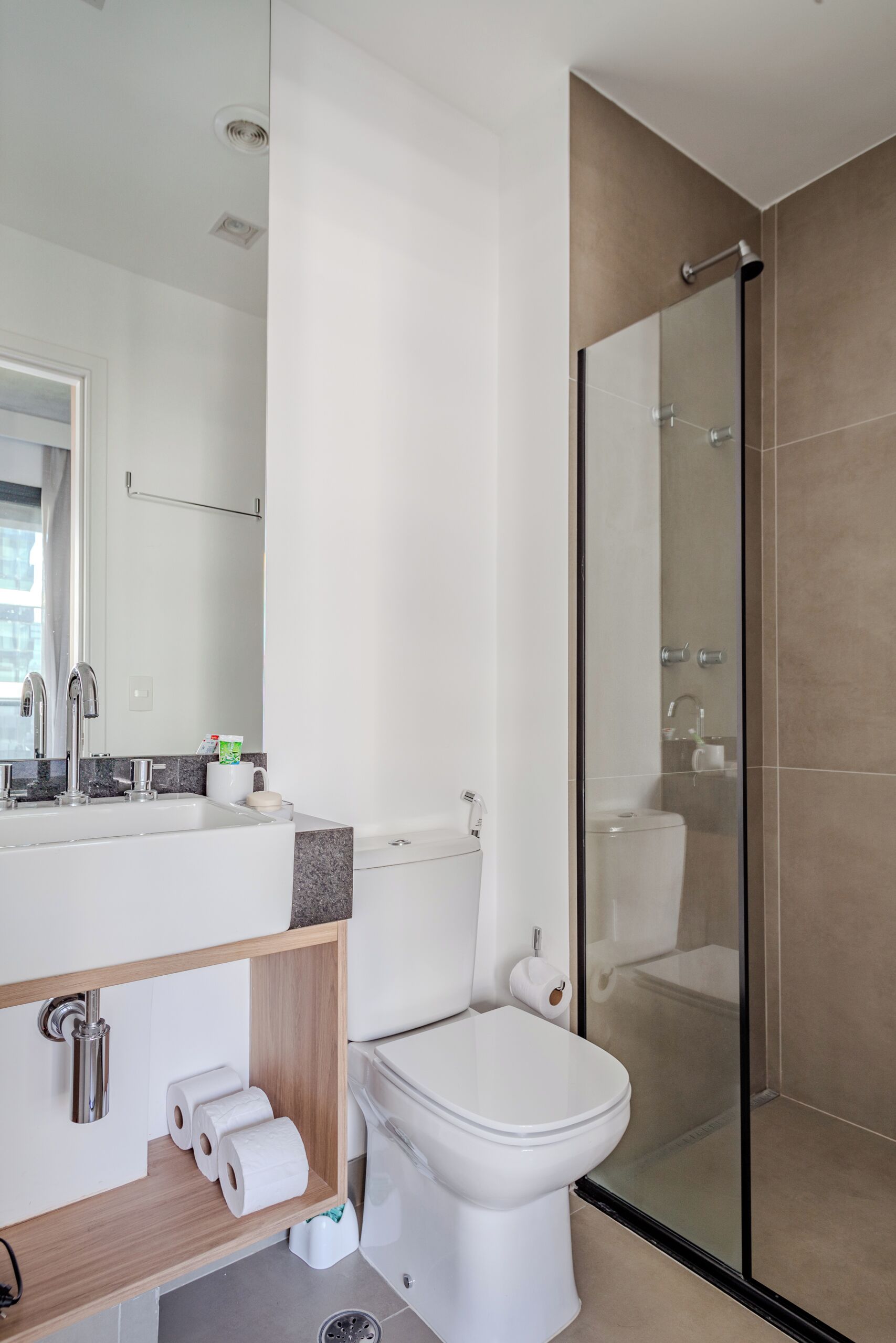 A modern bathroom with a shower, toilet, and sink.