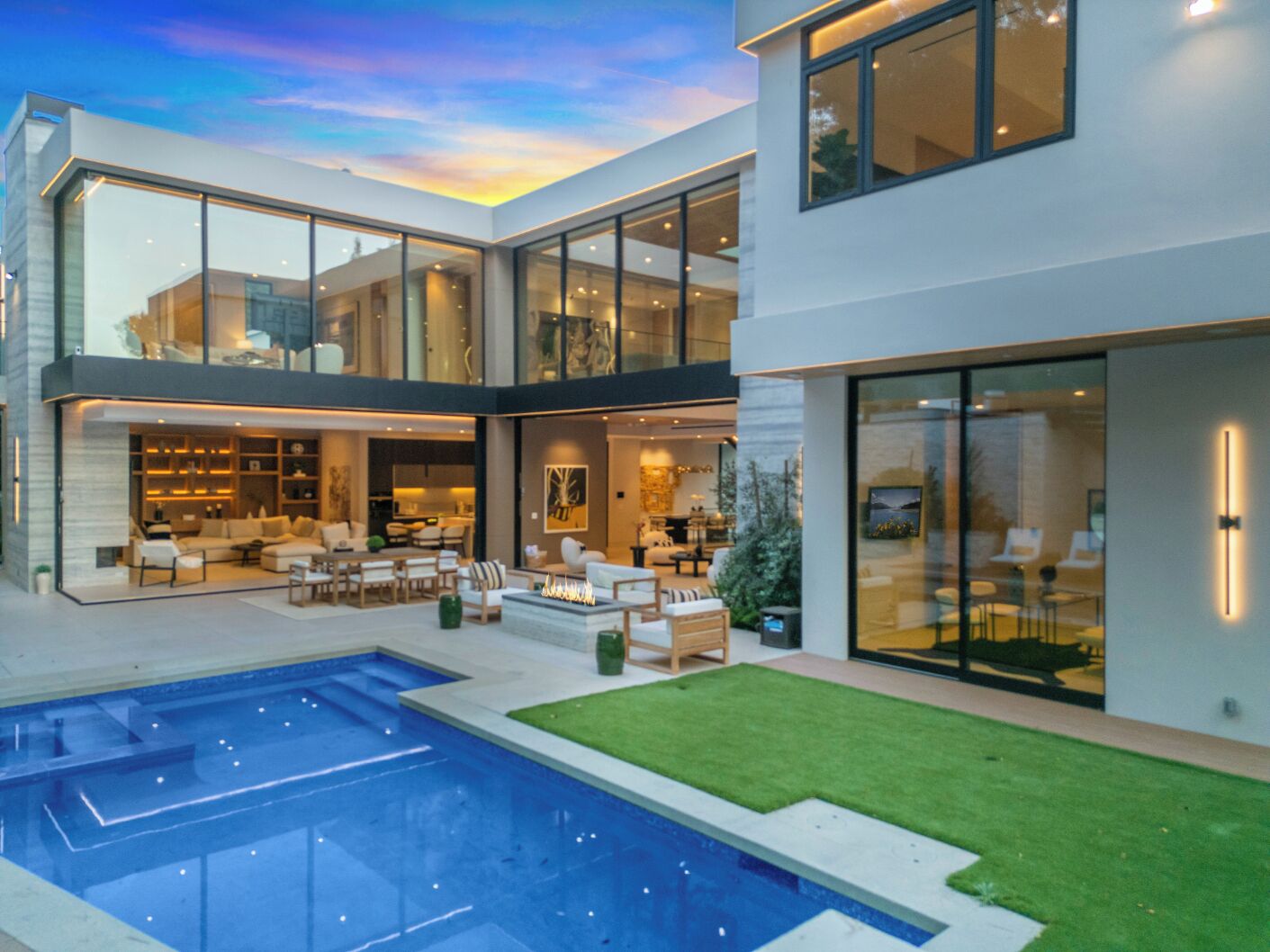 A modern house with a pool, multiple levels, and a well-lit interior.
