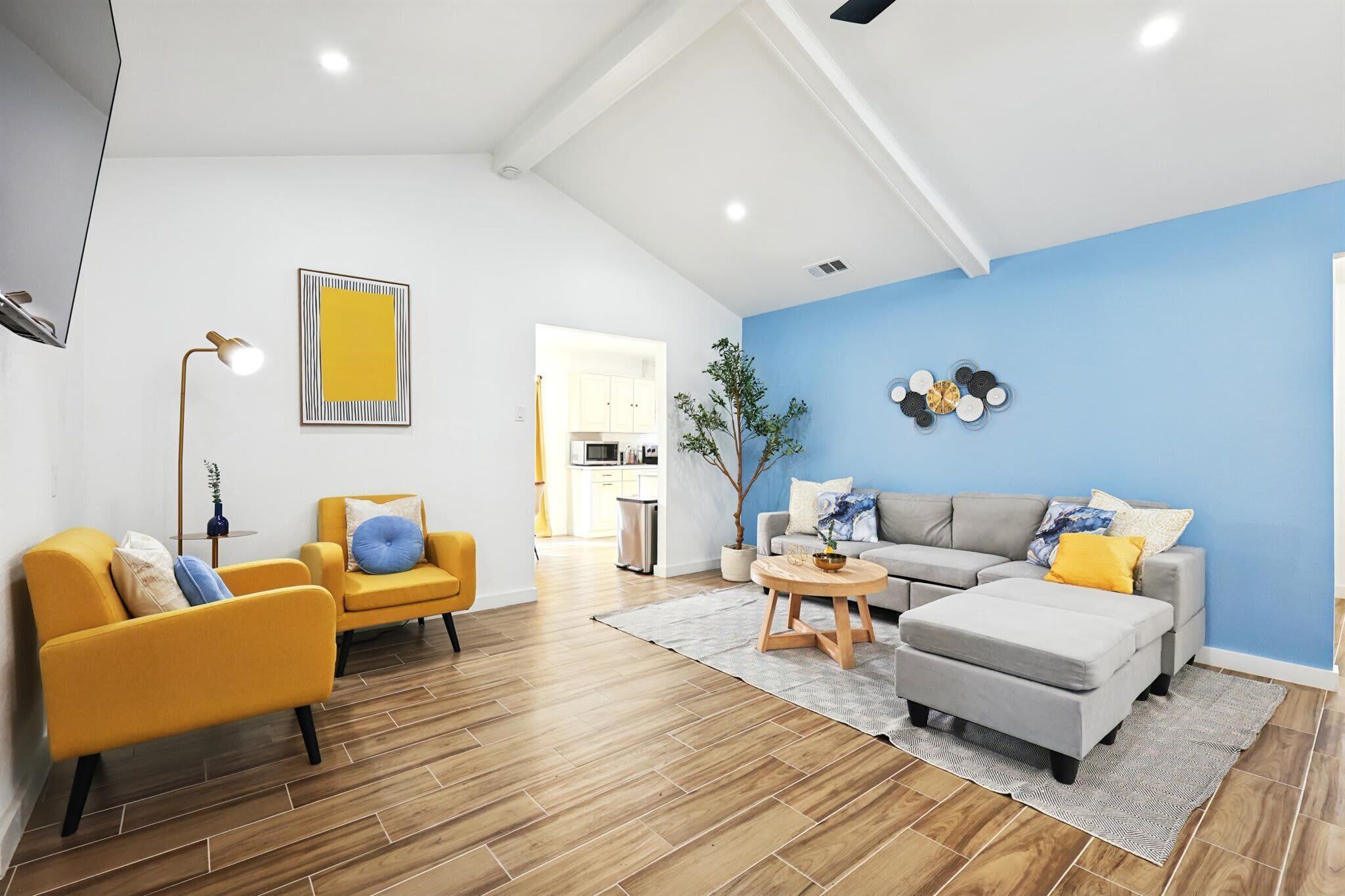 A living room with a sofa, armchairs, a coffee table, and a dining area with a table and chairs.