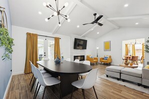 A modern living room with a dining area, a fireplace, and a ceiling fan. - Best of Desoto 4BR,3BA with Pool, HotTub, Cinema (DeSoto)