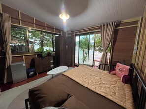 Une chambre avec un lit, un bureau et une vue sur la mer.