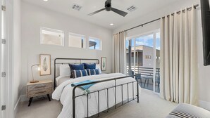 A bedroom with a bed, bedside table, lamp, and a view of the outside. - Villa #02 at Bloomington Country Club: Pool, Golf, Restaurant (St. George)