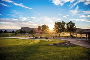 A golf course with a well-maintained lawn, a putting green, and a pavilion. - Villa #11 Adventure Retreat at Bloomington Country Club: Pool, Golf, Restaurant (St. George)