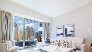 Une chambre d’hôtel moderne avec une grande fenêtre, un canapé, une petite table et une plante en pot.