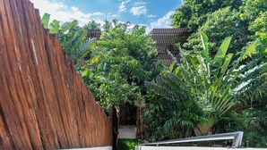 A wooden staircase leading to a covered area surrounded by lush greenery and a wooden fence. - Villa in Tulum with Private Pool and Jacuzzi (Tulum)