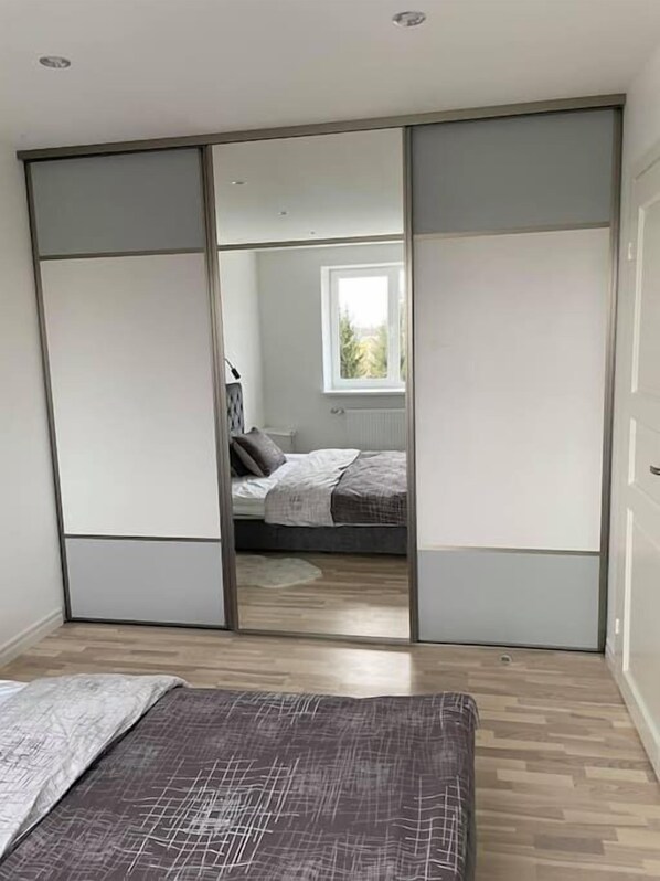 Une chambre à coucher avec un lit, une armoire et une fenêtre.