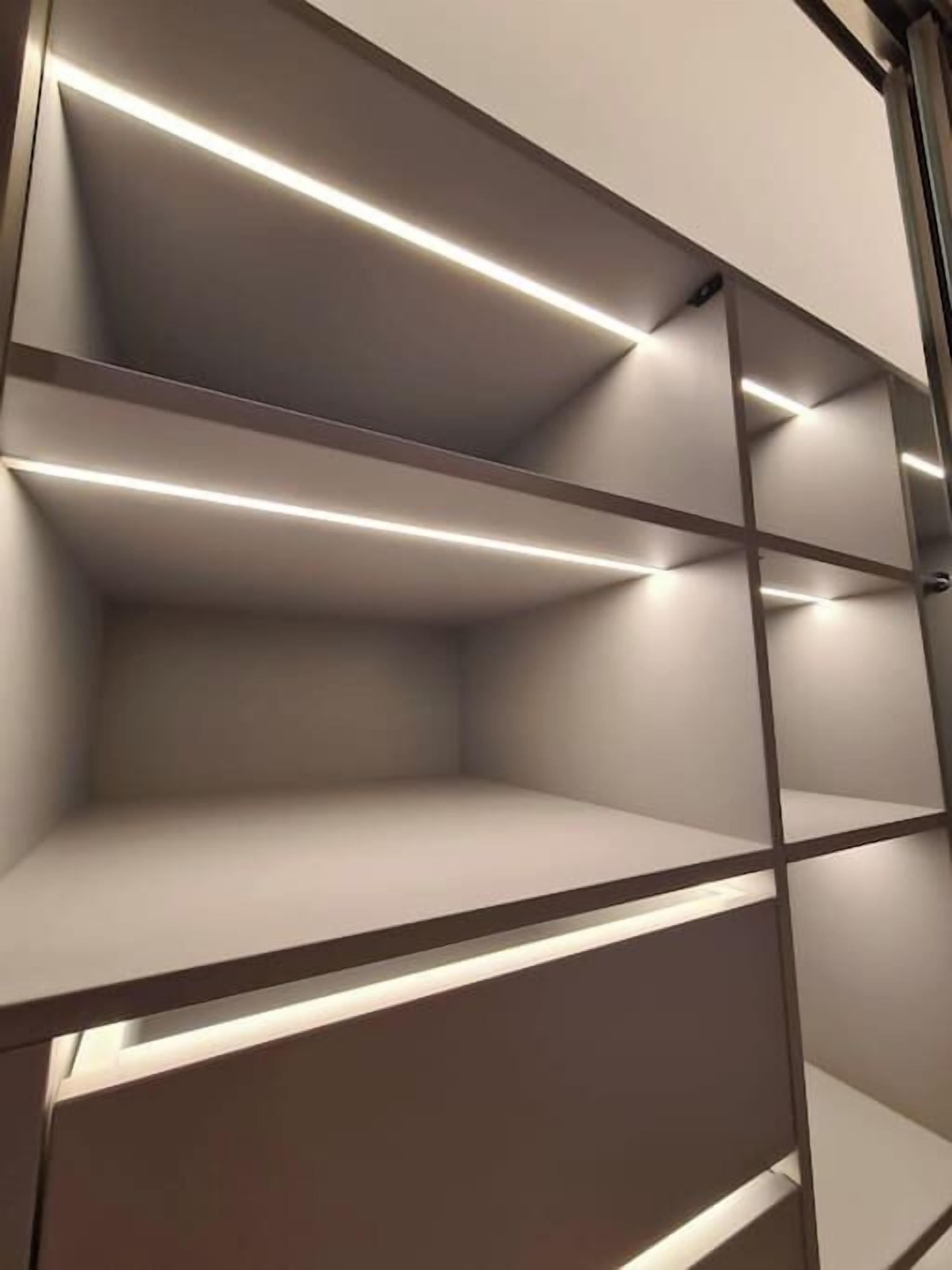 Un intérieur moderne et minimaliste, doté d’étagères intégrées et d’un éclairage intégré.