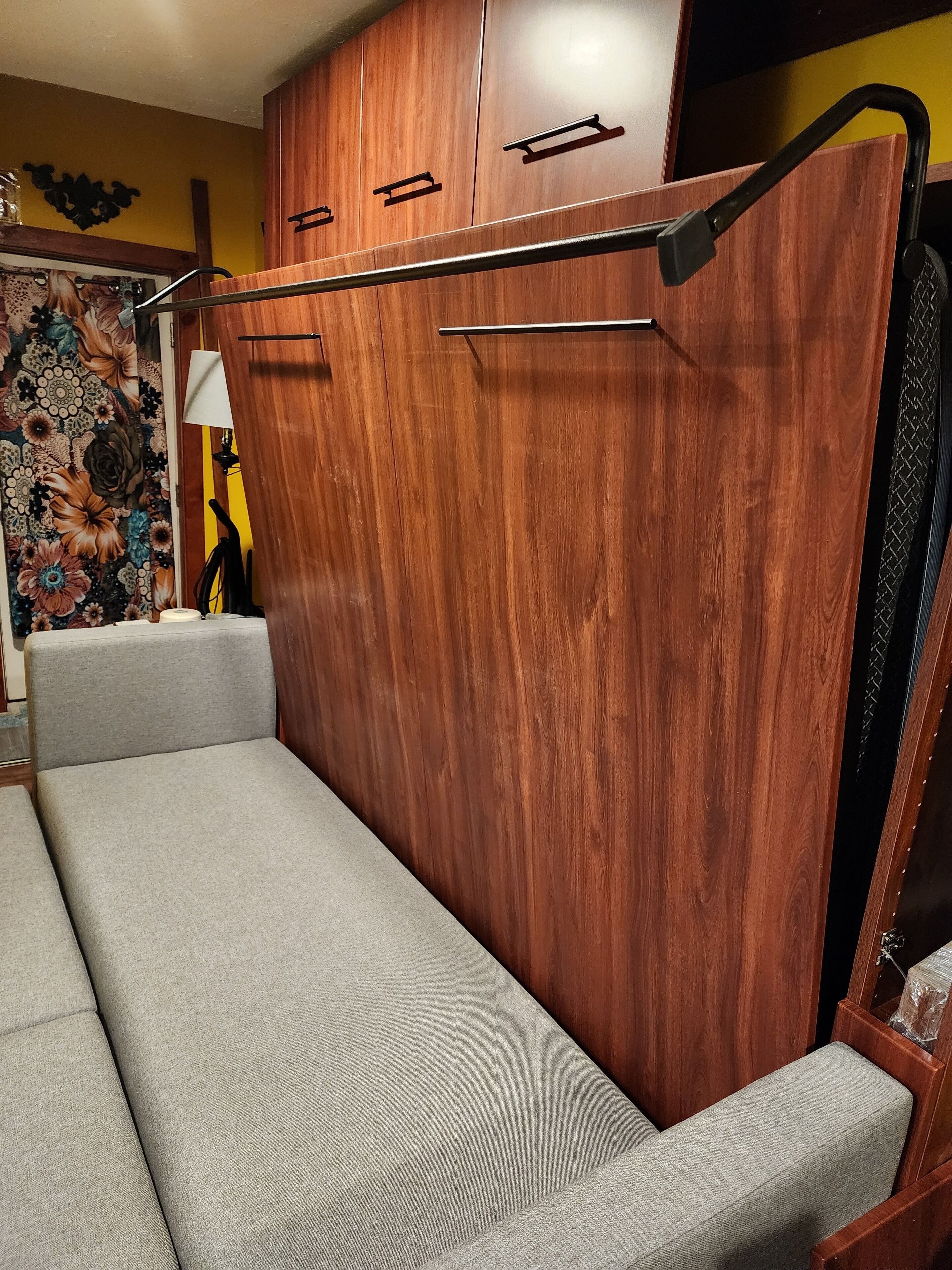 Une pièce de taille modeste, dotée d’un canapé intégré, d’une armoire en bois et d’un mur décoratif.