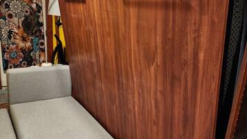 Une pièce de taille modeste, dotée d’un canapé intégré, d’une armoire en bois et d’un mur décoratif.