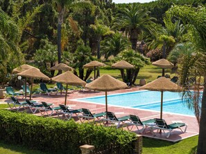 Piscine extérieure en saison, parasols, chaises longues