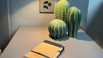 A table with a notebook, two cactus sculptures, and a light switch.