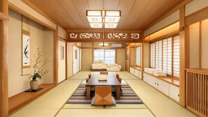 A traditional Japanese room with tatami flooring, a low table, and sliding doors. - Cozy 5 room house in Tokyo, 2 minutes from station. WiFi, Netflix, Full Kitchen. (Senju Akebonocho, Adachi Ward)