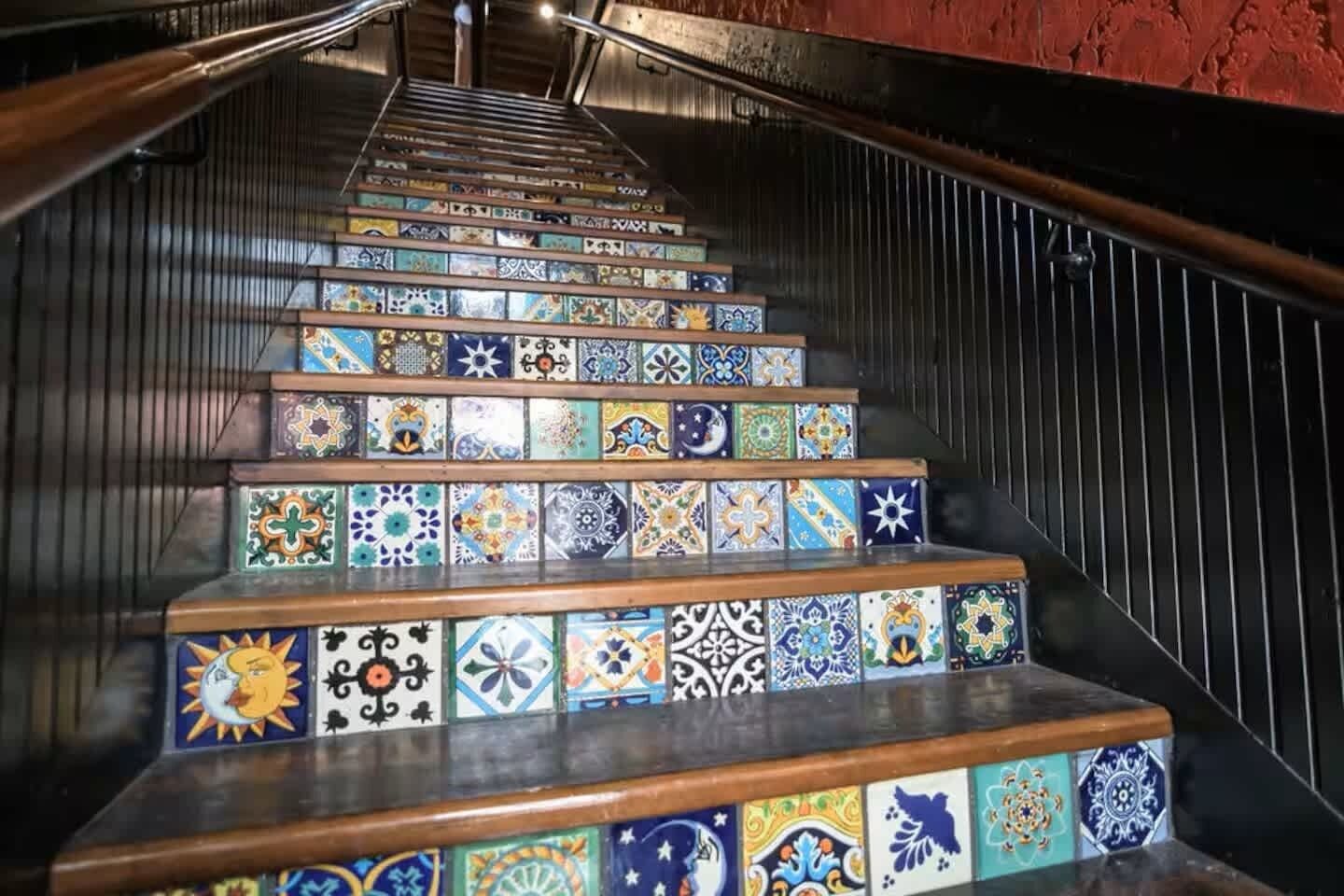 A staircase with colorful tiles and wooden steps.
