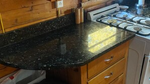 A kitchen with a black granite countertop, wooden cabinets, and a gas stove. - Relax at this peaceful place w/kayaks and dock available for personal boats (Weston)