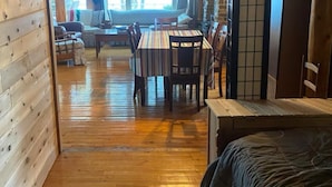 A wooden-floored room with a dining table and chairs, a sofa, and a bed. - Relax at this peaceful place w/kayaks and dock available for personal boats (Weston)