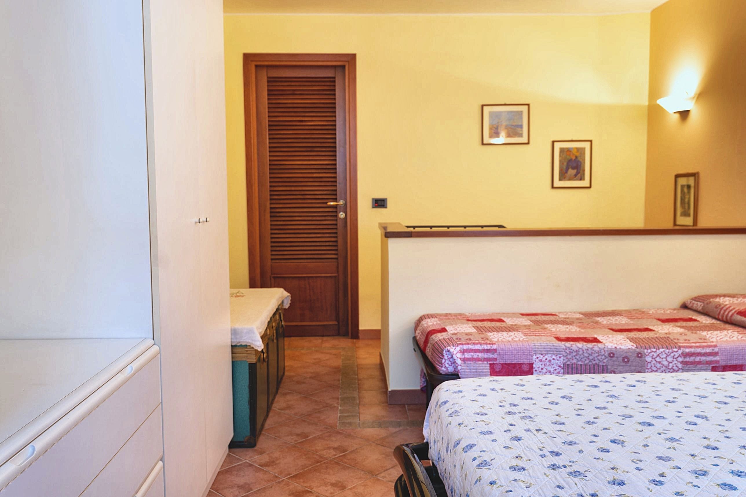 Ein Schlafzimmer mit zwei Betten, einer Holztür und einem kleinen Tisch.