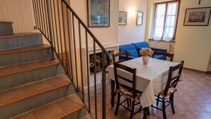 A dining area with a table, chairs, and a vase of flowers. - Suite Carla Cozy Apartment in Petrasanta Center (Pietrasanta)