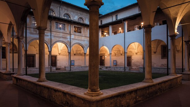 An open courtyard with arches and columns, surrounded by buildings with balconies. - Suite Carla Cozy Apartment in Petrasanta Center (Pietrasanta)