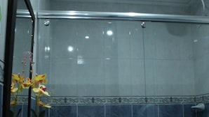 A bathroom with a white sink, a mirror, and a shower. - Hotel Windsor Colombia (Bogotá)