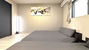 A modern bedroom with a large bed, a wall-mounted air conditioner, and a window with curtains. - NEW! [Built in 2024, Entire Newly Built House for Rent / Free Parking Available] Experience Osaka’s Old Town! Conveniently located just 8 minutes by train from Namba! Excellent access to Osaka, Kyoto, and Nara! (大阪市)